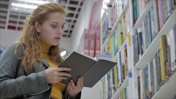 Portrait of a Young Beautiful Woman with Bright Red Hair in Glasses, Pretty Girl Reading in Book alt