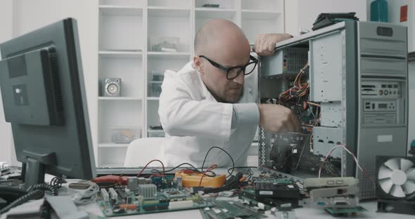 Technician damaging a computer with a screwdriver