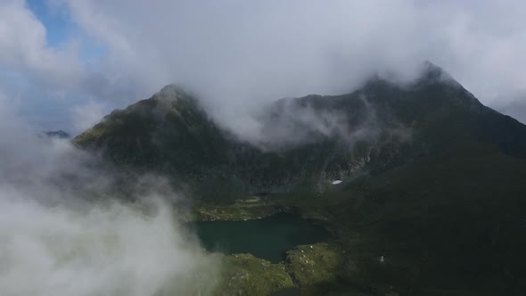 Flying Through Clouds Over Mountain and Lake