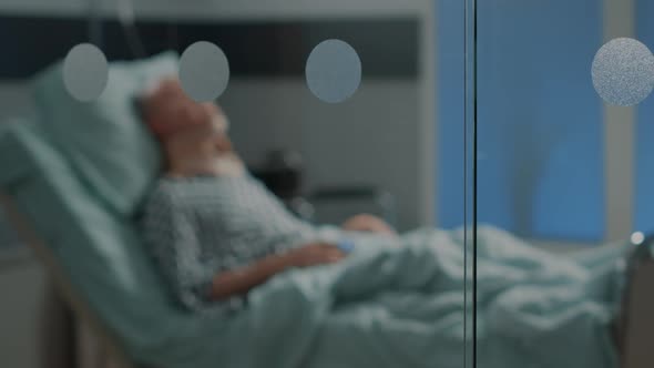 Sick Old Man Laying in Hospital Ward Bed with Cervical Neck Collar alt