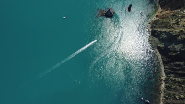 Aerial View From Above on Calm Azure Sea and Volcanic Rocky Shores alt