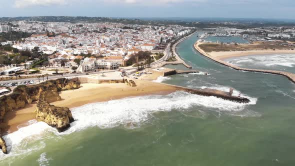 Panoramic view of the beach, marina and cityscape, Lagos, Algarve, Portugal. Aerial froward alt