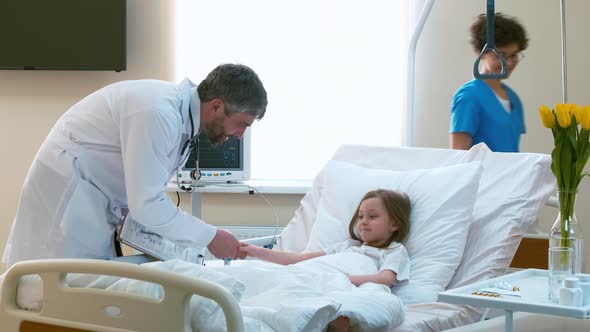 Doctor greeting little girl in hospital room