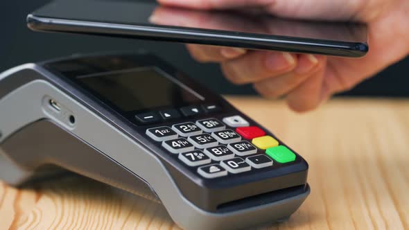 Contactless Payment with Smartphone. Wireless Payment Concept. Close-up, Woman Using Smartphone alt