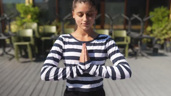 Woman Doing Yoga Exercises on House Roof in Early Morning alt