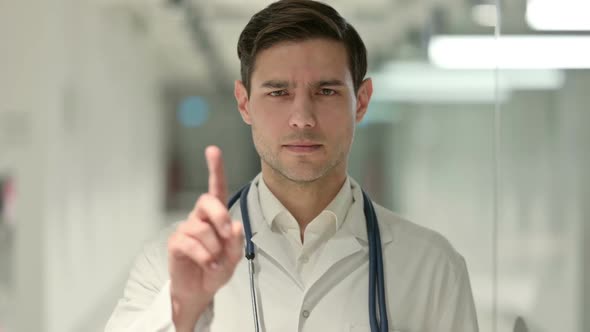Portrait of Male Doctor Showing No Sign with Finger Gesture alt