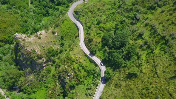 Aerial Top Down Cars Driving on Winding Serpentine Road, Camera Locked Above Twisted Mountain Road
