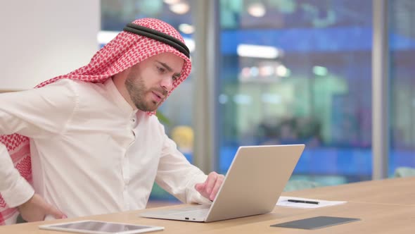 Tired Arab Businessman with Laptop Having Back Pain in Office alt