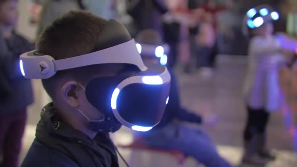 Child sits in VR glasses at a robotics exhibition