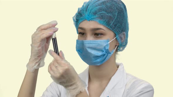 Young Woman Doctor in Protective Mask with Blood Test Tube alt