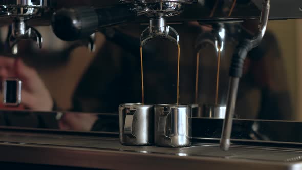 Coffee machine. Pouring coffee into cups close-up alt