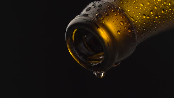 Wet beer bottle neck with falling drops 