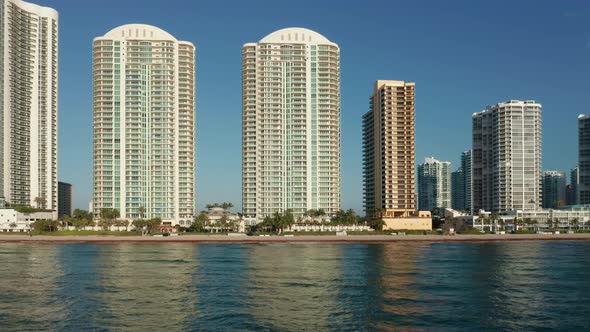 Beautiful City Skyline at Sunrise. White Buildings Reflecting in Atlantic Ocean alt