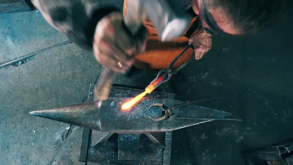 One Blacksmith Shapes Knife on Anvil, Using Hammer alt