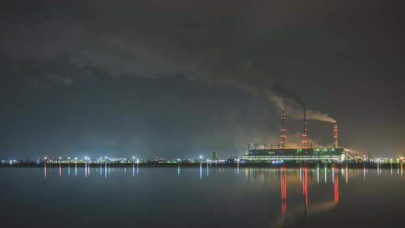 Time Lapse of Coal Power Plant High Pipes with Black Smoke Moving Fast Polluting Atmosphere at Night alt