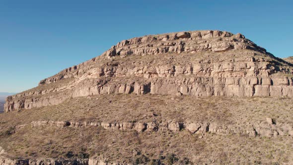 Drone aerial fly-by of a large cliff face with layers of rock and washout alt