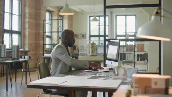 Black Architect Working on Computer and Leaving Office alt