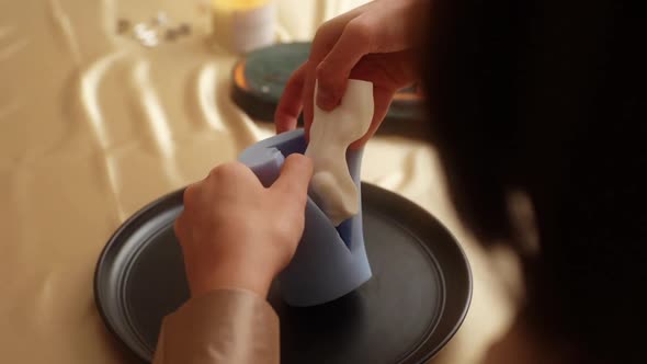 Closeup View From Back of Unrecognizable Talented Female Artisan Takes Beautiful White Piece of alt