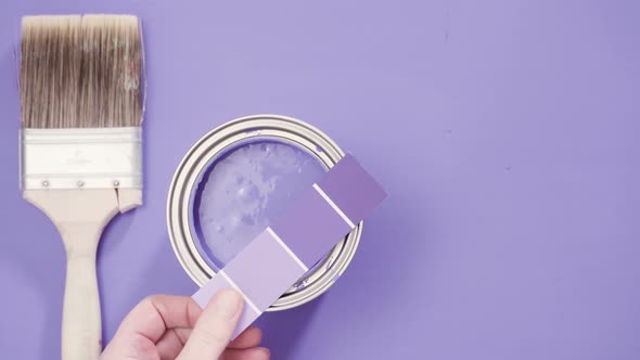 Close up of metal paint can with purple paint and paint swatch. alt