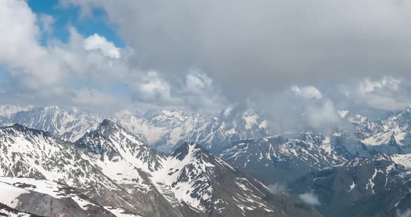 Air Flight Through Mountain Clouds Over Beautiful Snowcapped Peaks of Mountains and Glaciers alt