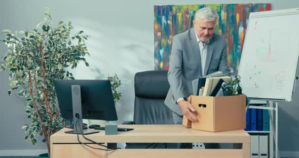 Ambitious Older Man with Gray Hair Wearing a Shirt Stands in Front of Desk in Corporate Office alt