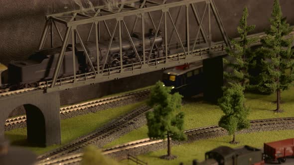 Model Vintage Train Moving Through Bridge. alt