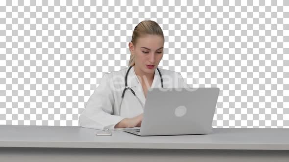 Seriouse female doctor working on her laptop, Alpha Channel