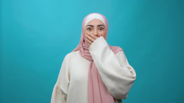 Frightened Young Muslim Woman in Hijab Closing Her Mouth with Hand and Looking Intimidated Scared at