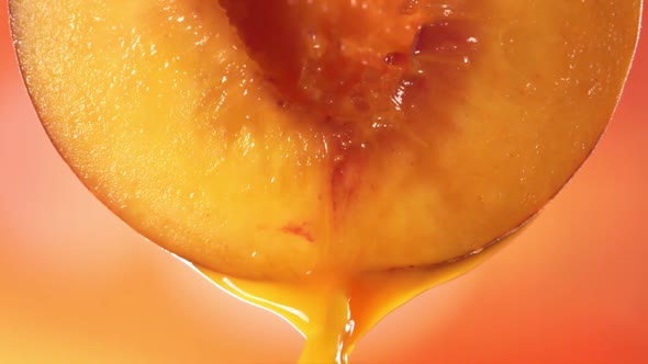 Slow Motion Macro Shot of Flowing Peach Juice From Half Peach alt