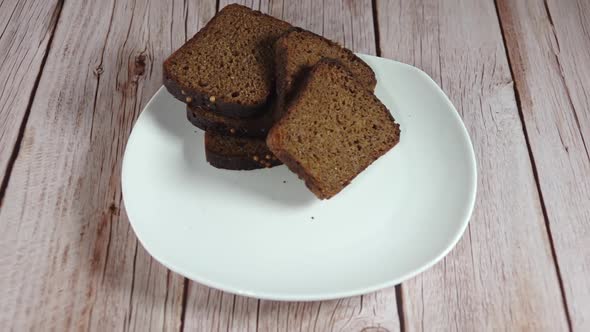 Two Slices of Rye Bread Fall on the White Plate