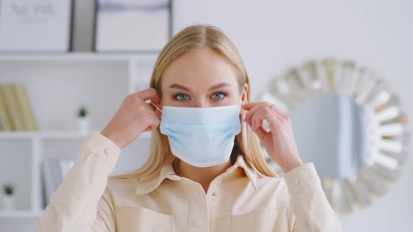Young smiling girl taking off his mask indoors. Smiling woman without mask alt
