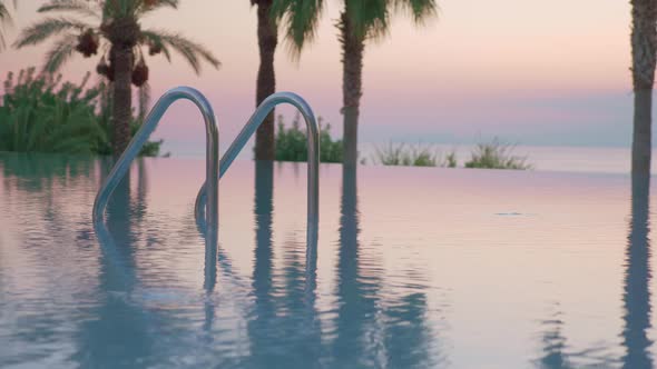 Outdoor swimming pool on resort, view at sunset alt