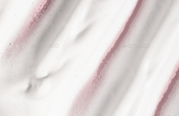 Cosmetic foam of white color on a pink background, facial wash, cream, soap for hygiene.