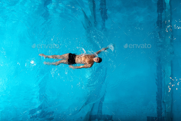 top view of sportsman in swimming trucks training in swimming pool