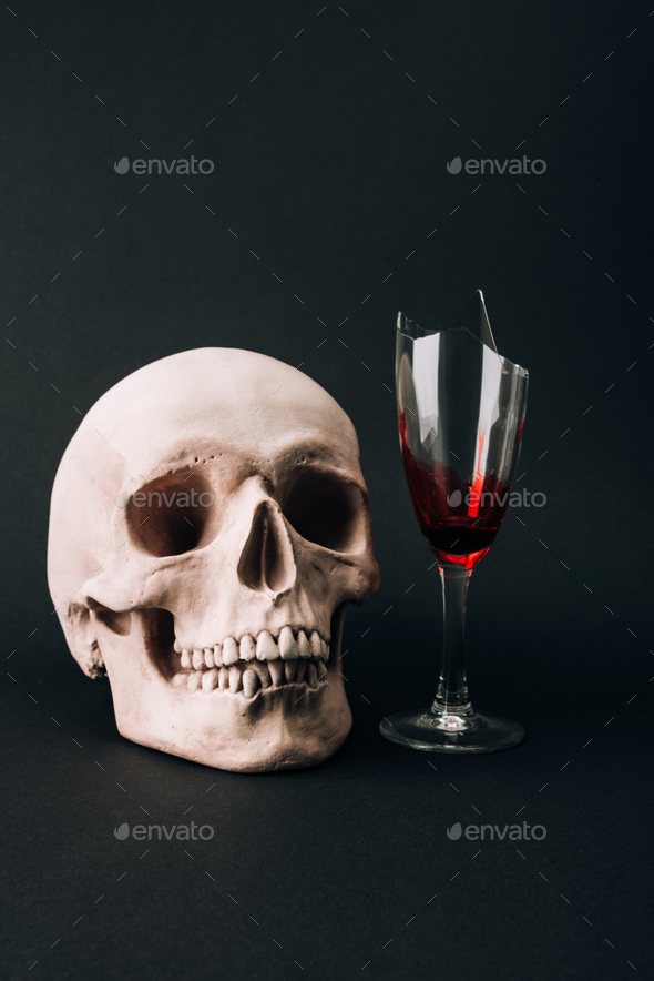 Skull and broken glass with blood isolated on black