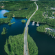 Aerial view of asphalt road with cars over blue lake and green woods in Finland - PhotoDune Item for Sale