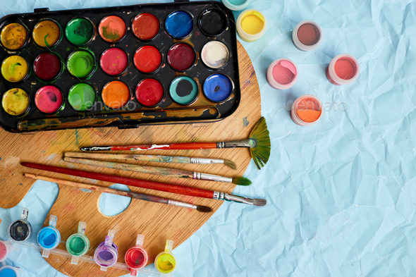 Flat lay of colorful paints, painting palette and brushes - Stock Photo - Images