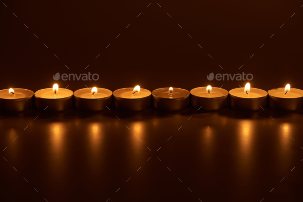 burning white candles glowing in dark - Stock Photo - Images
