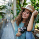Portrait of young woman with camera in botanical garden. - PhotoDune Item for Sale