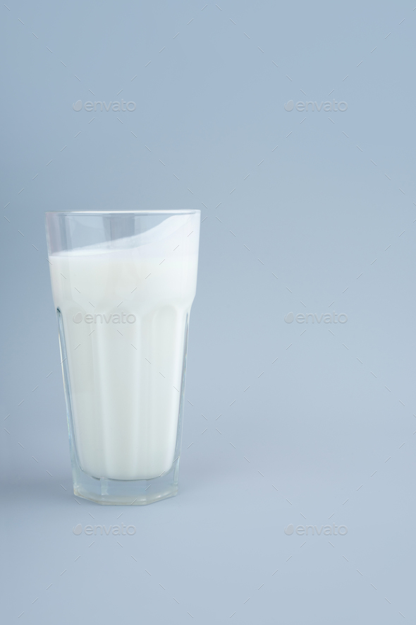 Probiotic drink, buttermilk or yogurt. Kefir in glass on minimalistic blue background