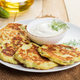Vegan zucchini pancakes in plate and cream sauce on wooden background. Healthy vegan diet food. - PhotoDune Item for Sale