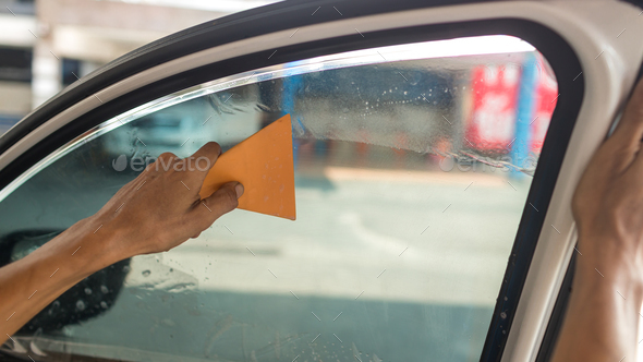 Technician Installing car window tint. - Stock Photo - Images
