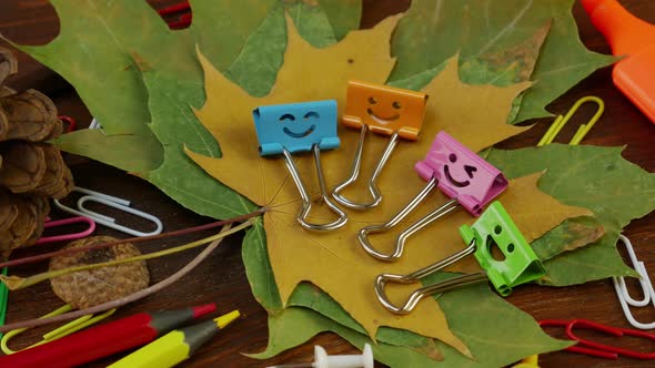 Smiles Binder Clips on Yellow Fallen Maple Leaves and School Office Supplies