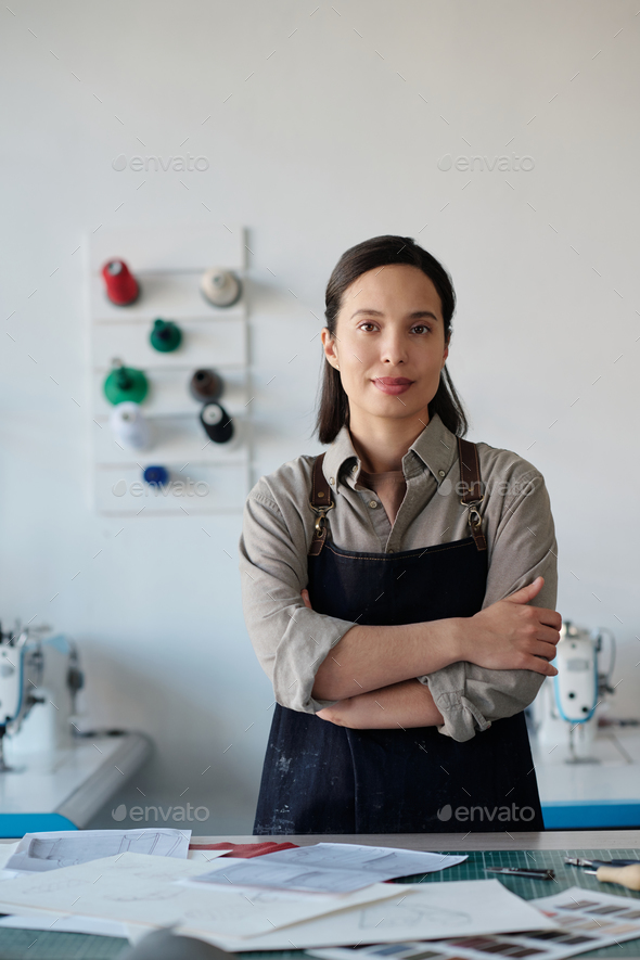 Young successful female tanner in workwear standing by workplace in studio - Stock Photo - Images
