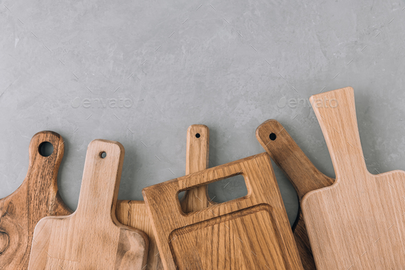 Chopping boards. Various wooden cutting boards on gray stone background - Stock Photo - Images
