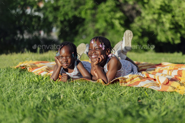 Happy two african american girls lying in the park - Stock Photo - Images