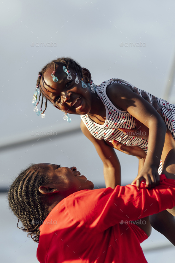 African mother playing with her daughter outdoors - Stock Photo - Images