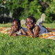 Happy two african american girls lying in the park - PhotoDune Item for Sale