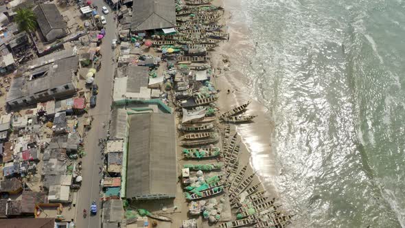 Breathtaking aerial view of fishing community with canoes along the bank alt