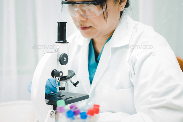 Asian scientist biochemist working research with a microscope in laboratory.  - Stock Photo - Images